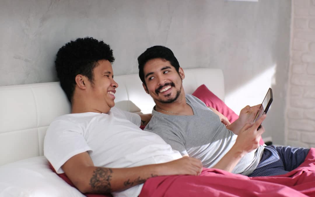 Gay Man Playing Video With Partner In Bed